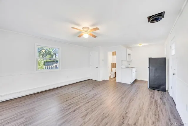 a view of empty room with wooden floor and window