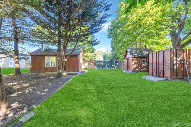 a view of backyard with small cabin and wooden fence