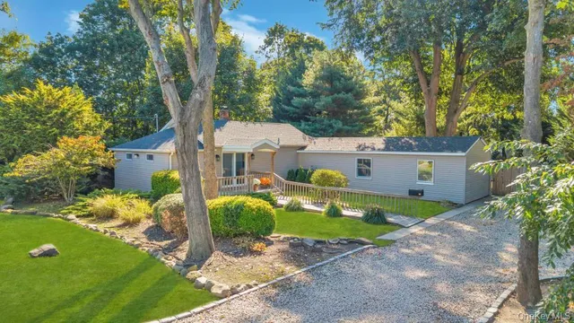 a view of a house with a big yard and a large tree
