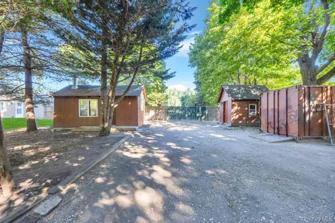 a front view of a house with a yard and tree s