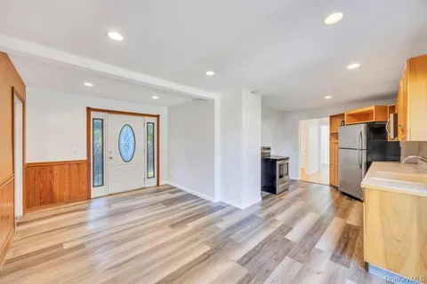 a view of a livingroom with a furniture staircase and a kitchen space