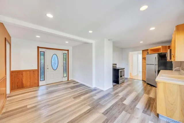 a view of a livingroom with a furniture staircase and a kitchen space