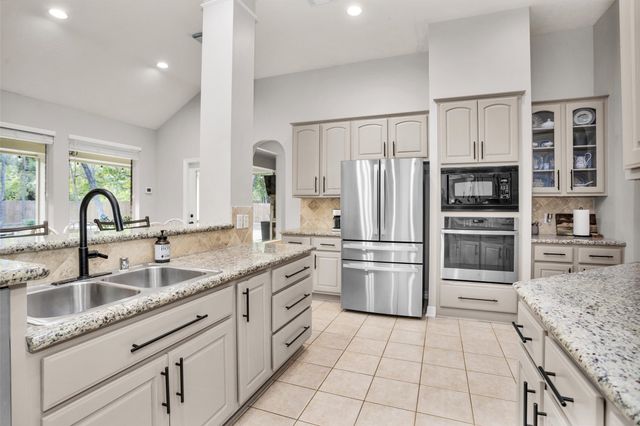 a kitchen with stainless steel appliances granite countertop a refrigerator and a sink