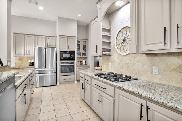 a kitchen with stainless steel appliances granite countertop a stove and a refrigerator