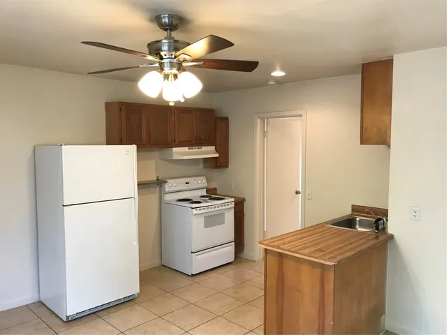 a kitchen with a stove a refrigerator and a chandelier