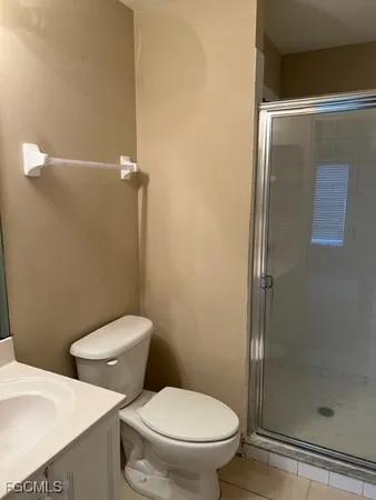 a white toilet sitting next to a shower