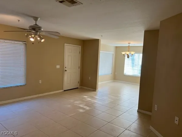 an empty room with windows and fan