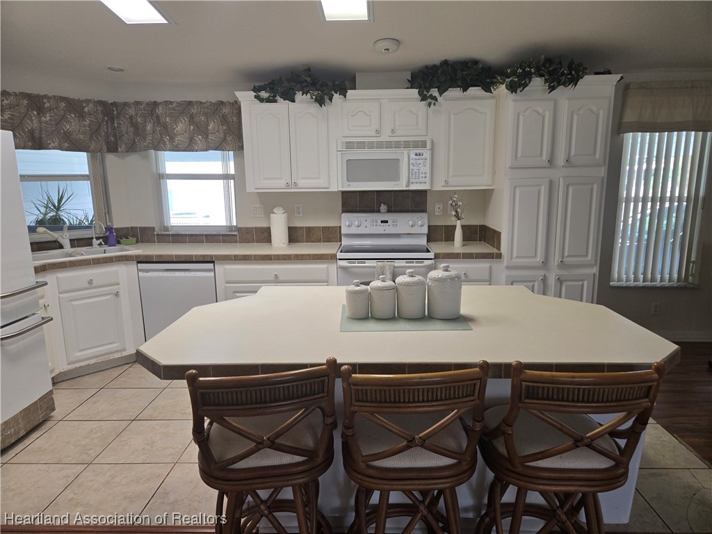 3312 Beartooth Pass Sebring, FL 33872 - Photo 5 of 39 a kitchen with a table chairs stove top oven and microwave