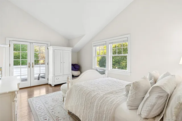 a spacious bedroom with a bed and wooden floor
