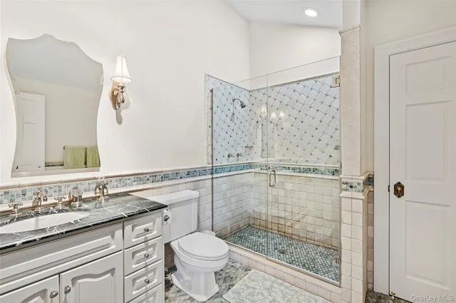 a bathroom with a granite countertop sink toilet and shower