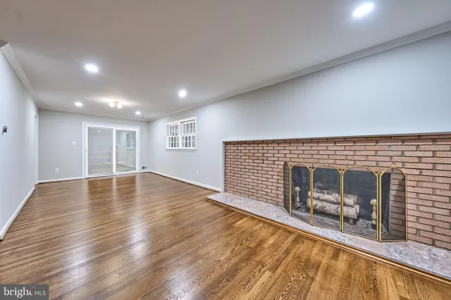 a view of empty room with wooden floor and fireplace