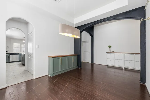 a view of a hallway with wooden floor and windows