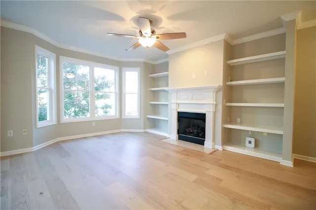 a view of an empty room with a fireplace and a window