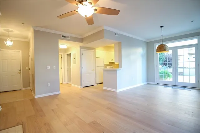 a view of empty room with wooden floor and window