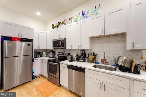 a kitchen with white cabinets sink and white appliances