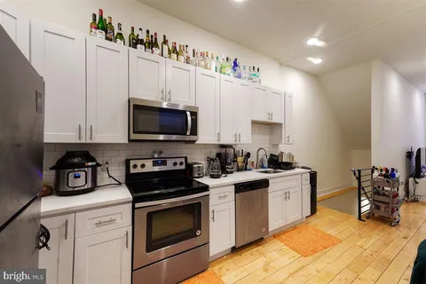 a kitchen with stainless steel appliances a stove a sink and a microwave
