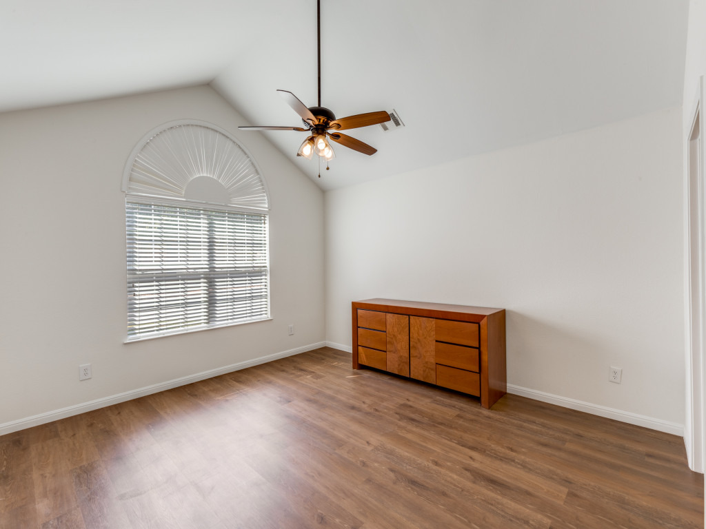 30 Wildwood Drive, Unit 174 Georgetown, TX 78633 - Photo 21 of 34 an empty room with wooden floor ceiling fan and windows