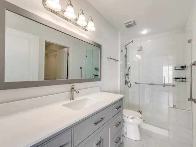 a bathroom with a sink a toilet and shower