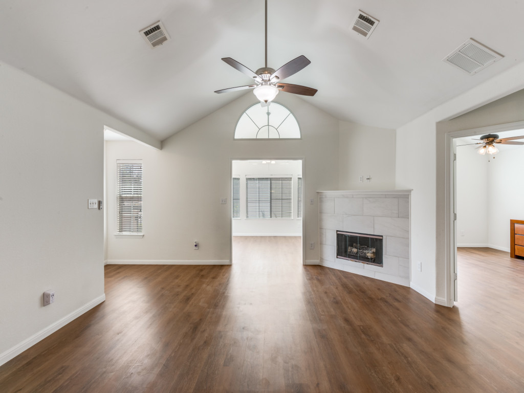30 Wildwood Drive, Unit 174 Georgetown, TX 78633 - Photo 6 of 34 an empty room with wooden floor a chandelier fan and a fireplace