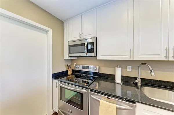 a kitchen with stainless steel appliances granite countertop a sink stove and microwave