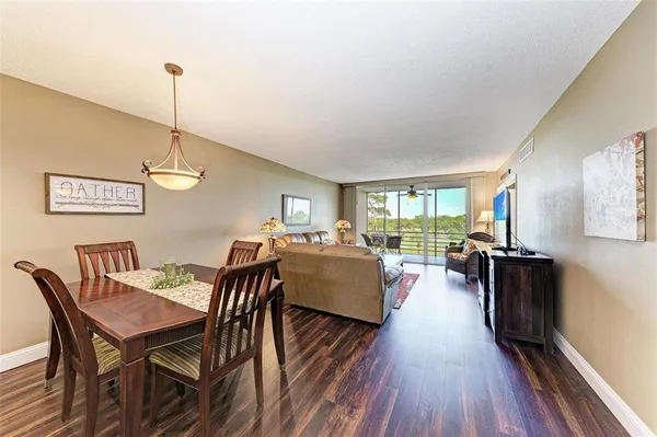a dining room with furniture wooden floor a rug and a chandelier