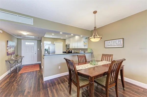a dining room filled chandelier and wooden floor