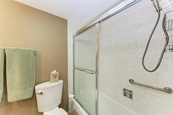 a bathroom with a granite countertop shower and a toilet