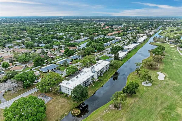 an aerial view of residential houses with outdoor space and trees