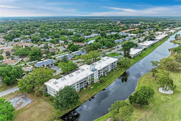 an aerial view of residential houses with outdoor space and trees