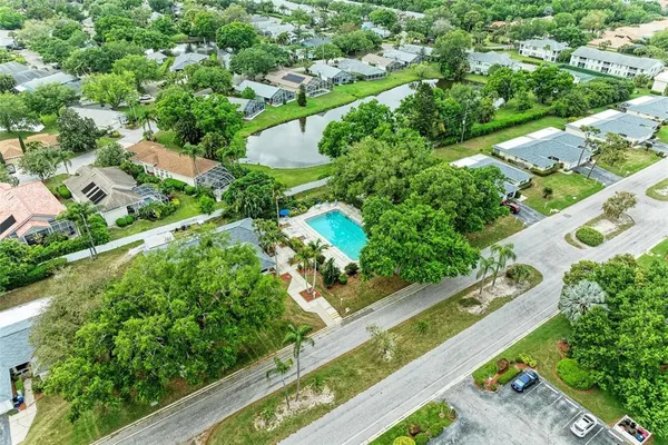 an aerial view of residential houses with outdoor space and trees