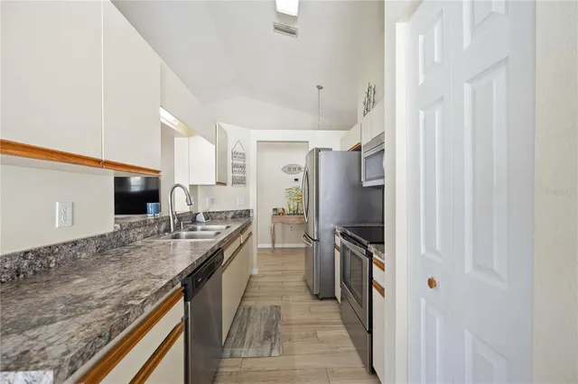 a kitchen with stainless steel appliances granite countertop a refrigerator and a sink
