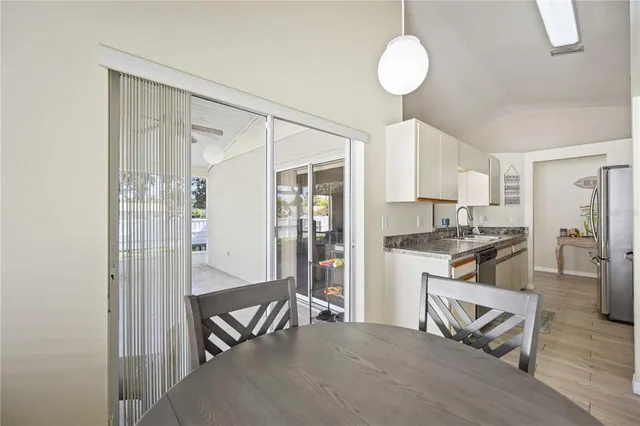 a living room with kitchen island furniture a sink and a refrigerator