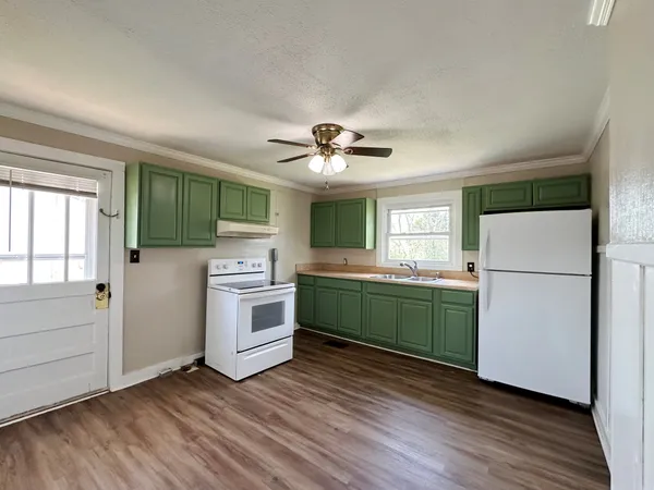 a kitchen with a refrigerator and a stove top oven