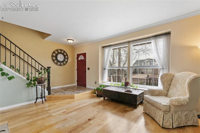 Foyer featuring tile entrance, wood floors, and stairs