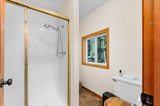 a bathroom with a granite countertop sink a mirror and a shower