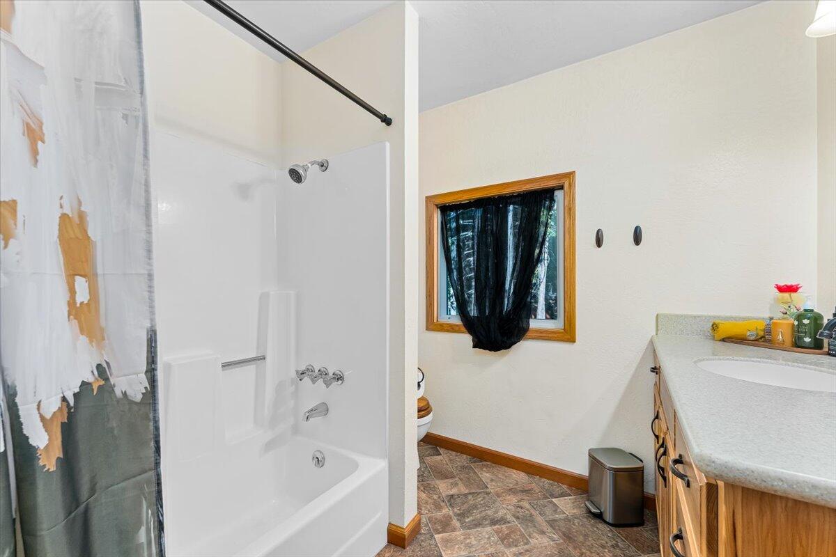 34820 Emigrant Trail Shingletown, CA 96088 - Photo 20 of 42 a bathroom with a sink and a shower curtain