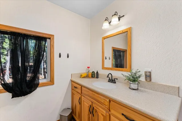 a bathroom with a sink a mirror and a window