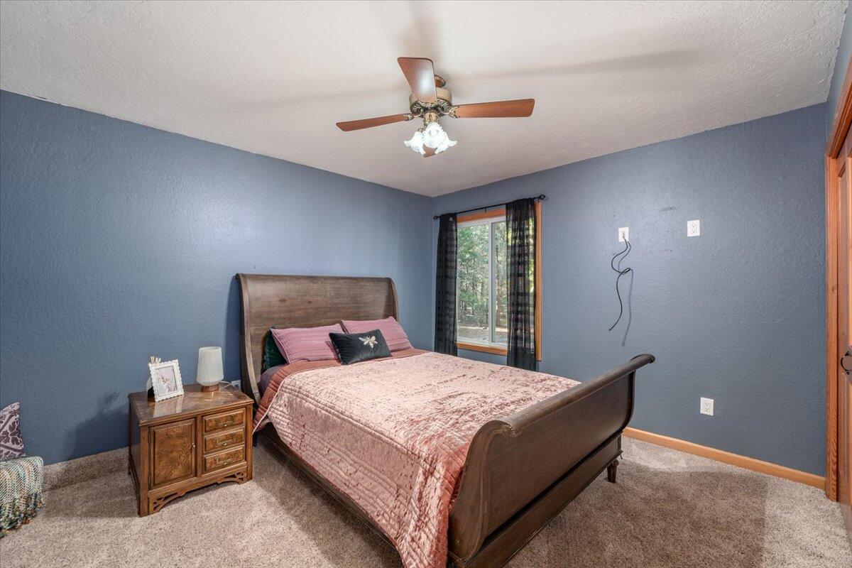 34820 Emigrant Trail Shingletown, CA 96088 - Photo 22 of 42 a bedroom with a bed and a chandelier