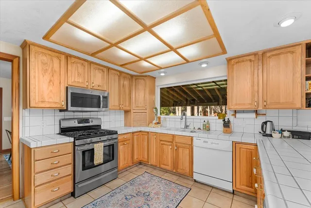 a kitchen with a sink white cabinets and appliances