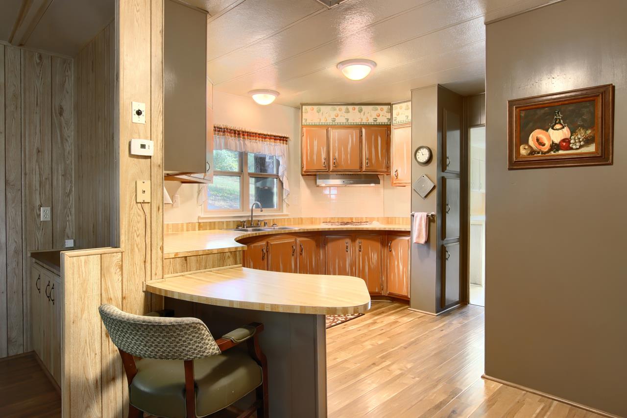 2843 East Westfall Road Mariposa, CA 95338 - Photo 18 of 45 a kitchen with a table chairs refrigerator and sink