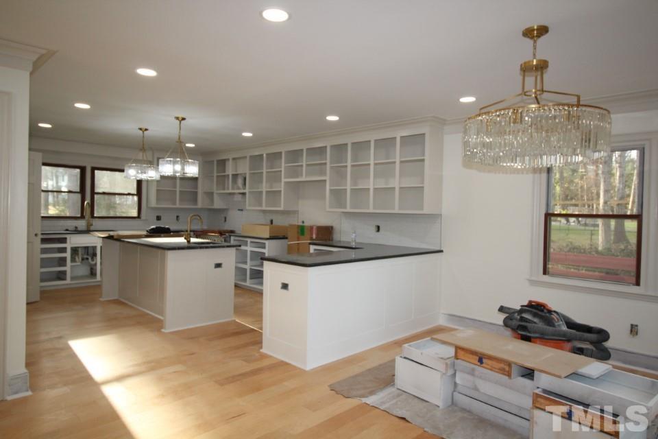 6516 Jade Tree Lane Raleigh, NC 27615 - Photo 9 of 30 a kitchen with kitchen island granite countertop stainless steel appliances lots of counter top space