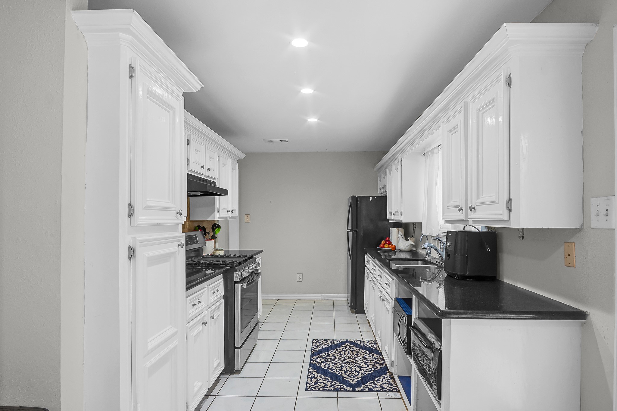 10939 Dunvegan Way Houston, TX 77029 - Photo 2 of 28 a kitchen with stainless steel appliances a sink a stove a microwave a sink a refrigerator and cabinets