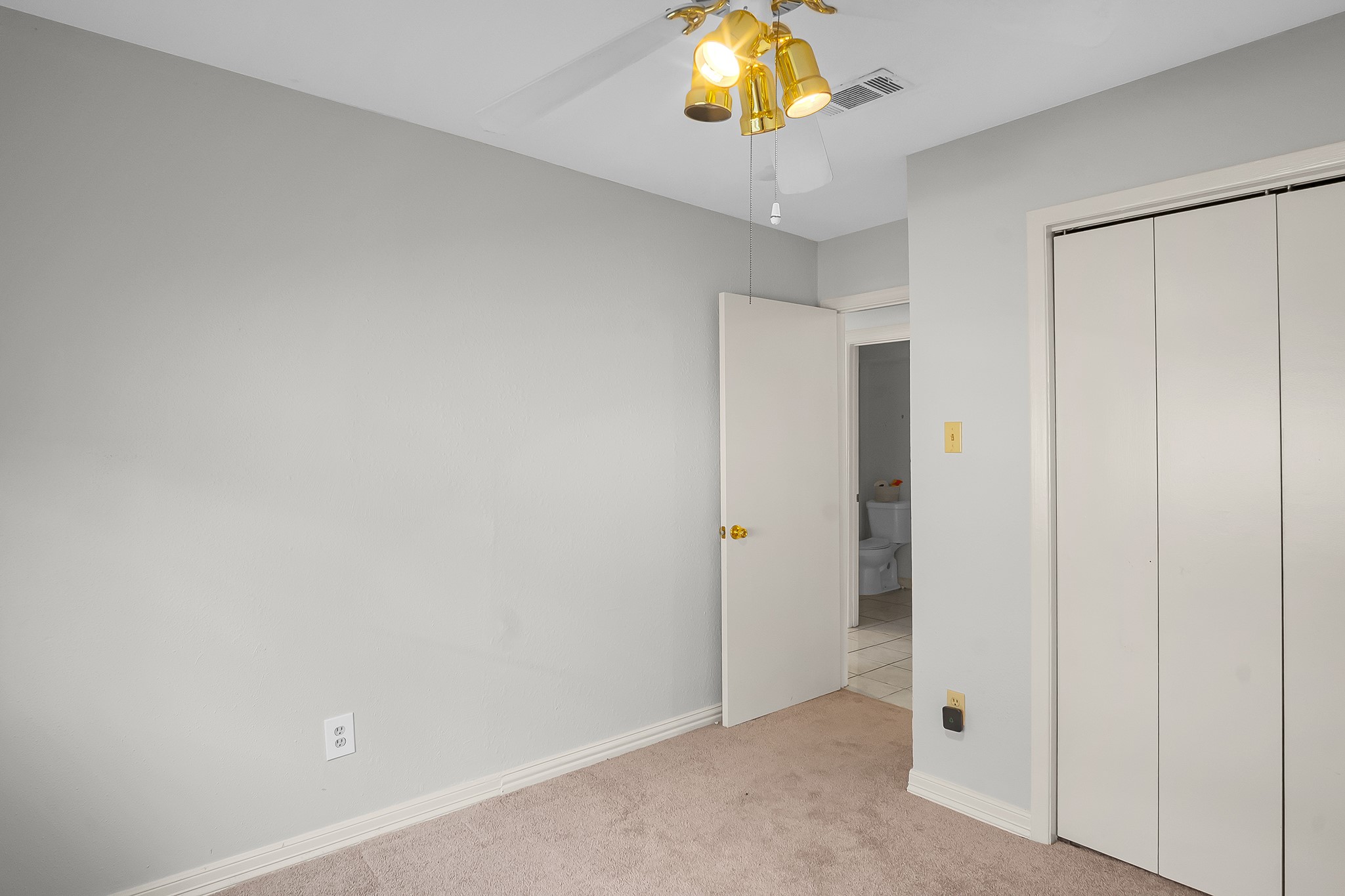 10939 Dunvegan Way Houston, TX 77029 - Photo 22 of 28 a view of an empty room and a chandelier fan