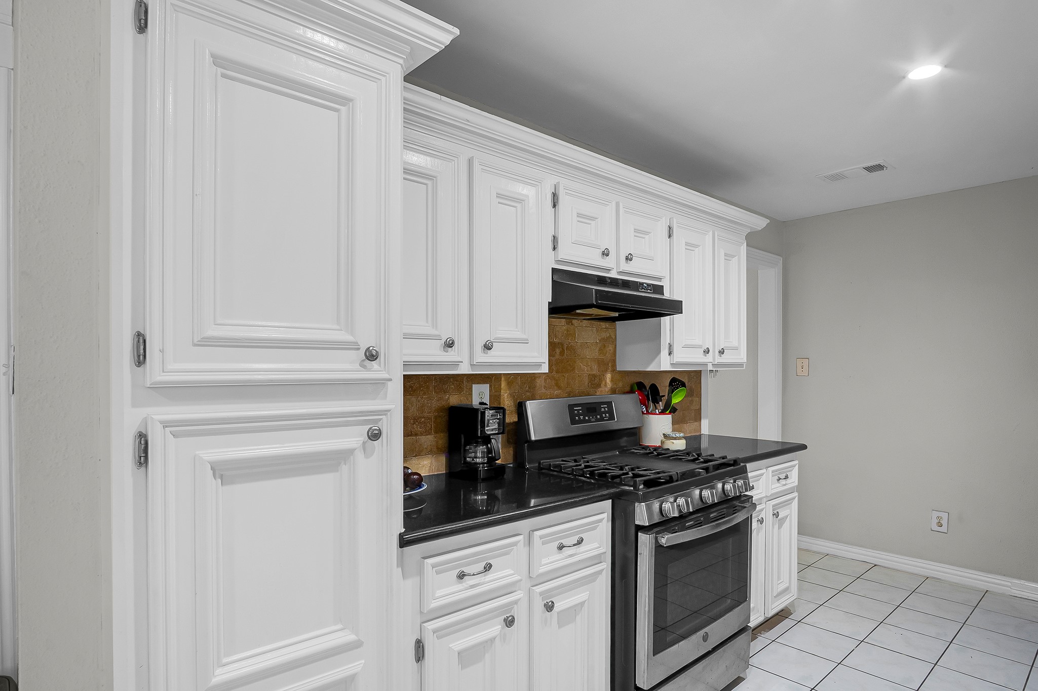 10939 Dunvegan Way Houston, TX 77029 - Photo 3 of 28 a kitchen with white cabinets and appliances