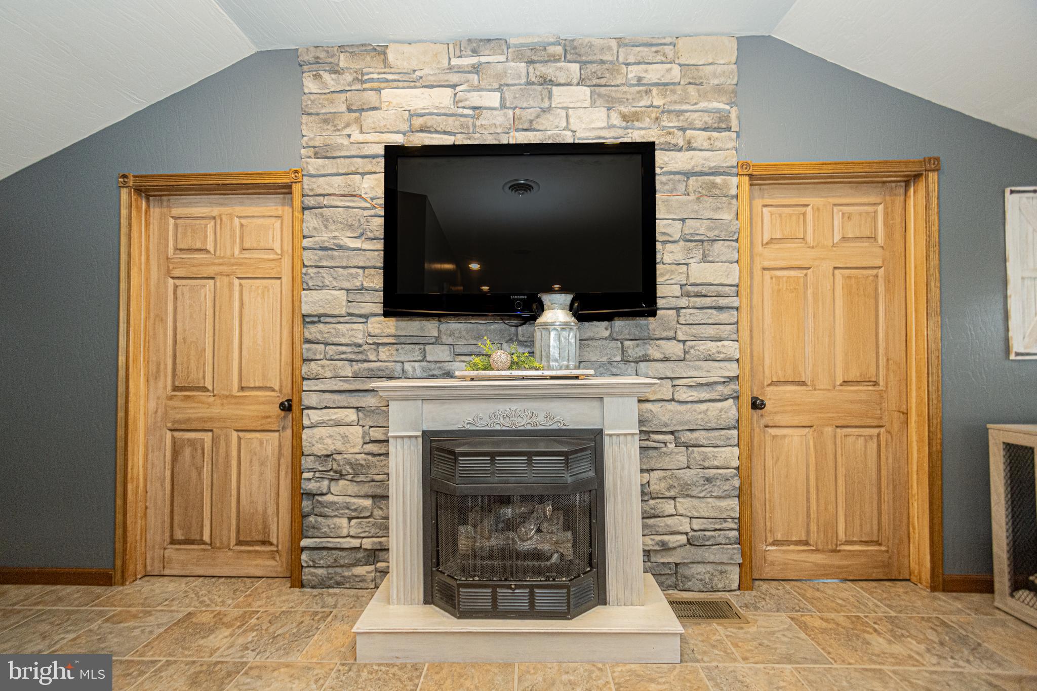 18 Springs Road Grantsville, MD 21536 - Photo 42 of 106 a living room with a fireplace and a flat screen tv