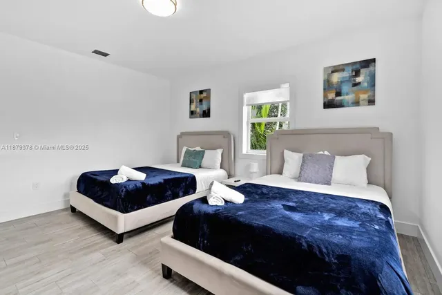 a bedroom with a bed a couch and a potted plant