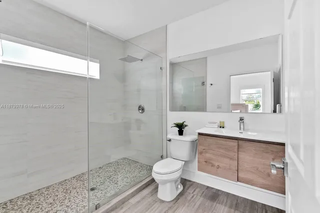 a bathroom with a toilet a sink and glass door