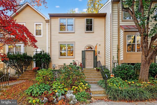 a front view of a house with a yard and potted plants