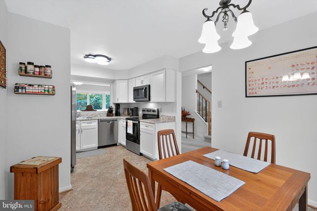 a kitchen with a table chairs refrigerator and microwave