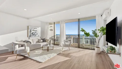 a kitchen with stainless steel appliances a dining table chairs and wooden floor